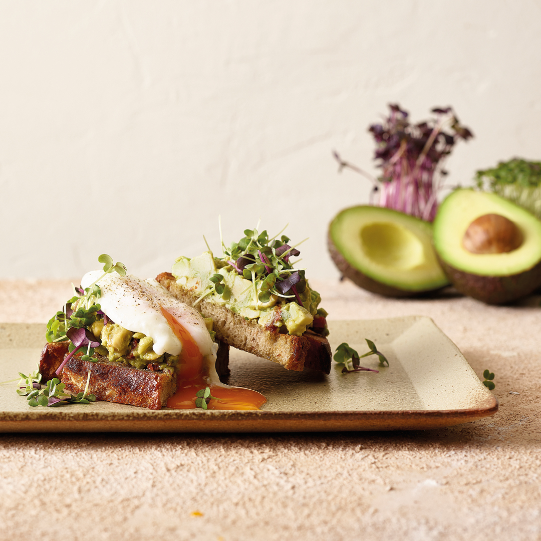 Pane di spelta con avocado e uova in camicia d'allevamento all'aperto
