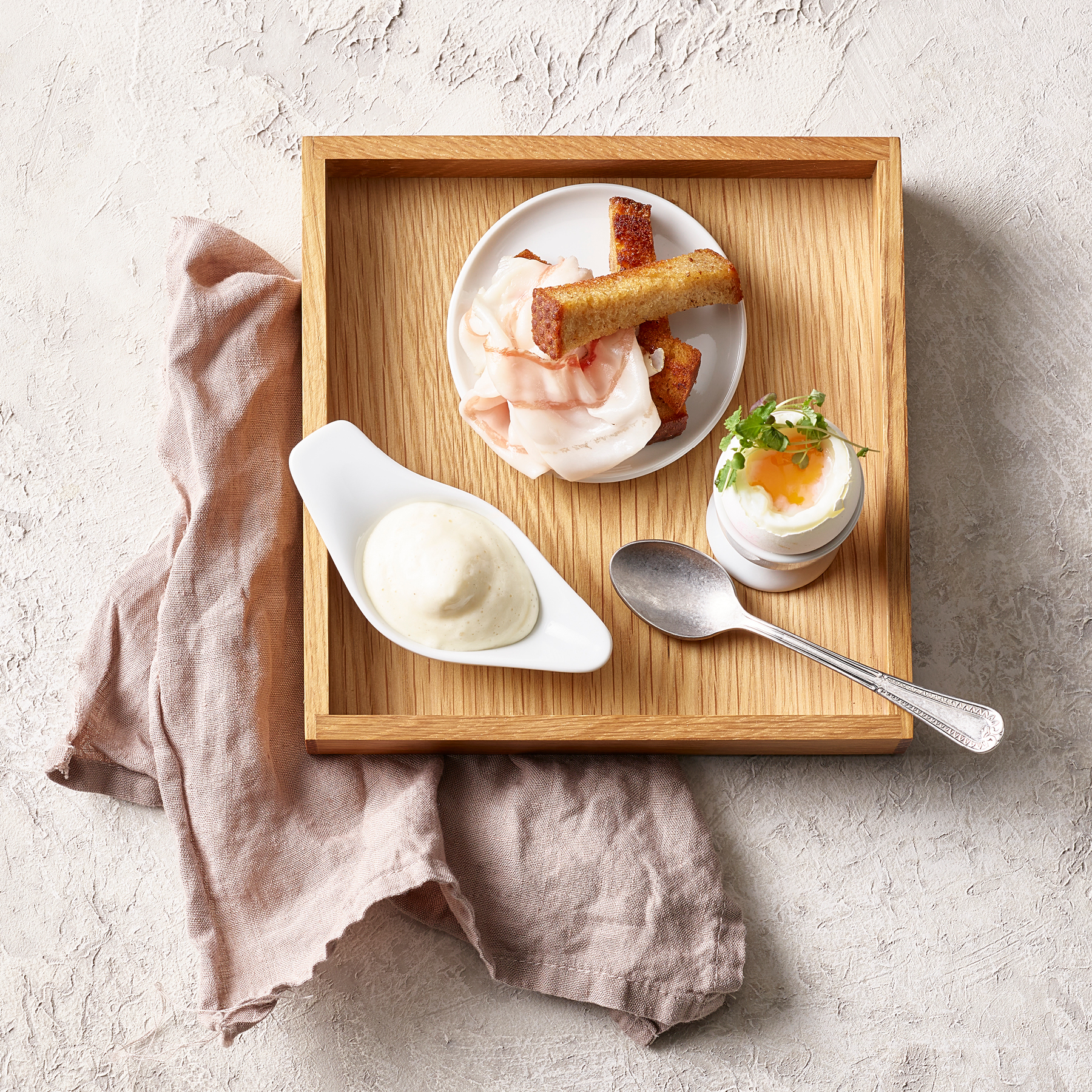 Uovo barzotto con espuma di spumante, bastoncini di pane e lardo