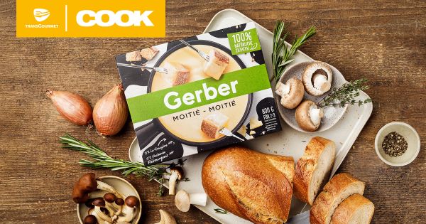 Eine Packung Gerber Moitié-Moitié Fondue, umgeben von frischem Brot, Pilzen und Kräutern.