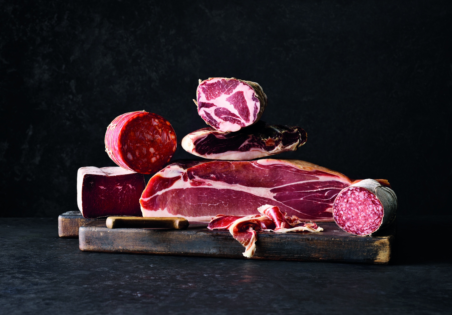 Wurstwaren wie Schinken, Speck, Salami auf dem Brett